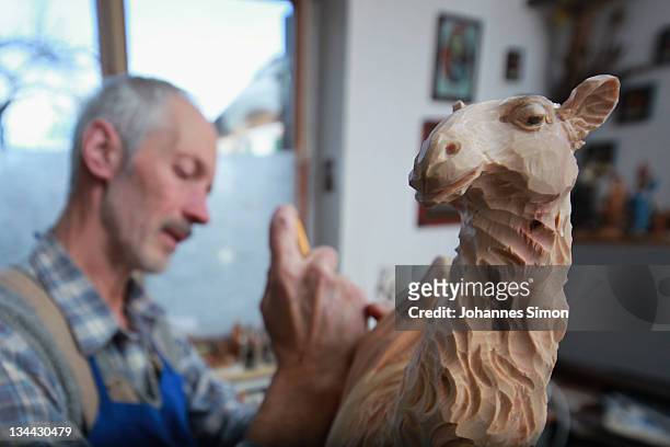 Woodcarver Herbert Haseidl carves a figurine in the shape of a dromedary for a Christmas crèche at his workshop on December 1, 2011 in Oberammergau,...