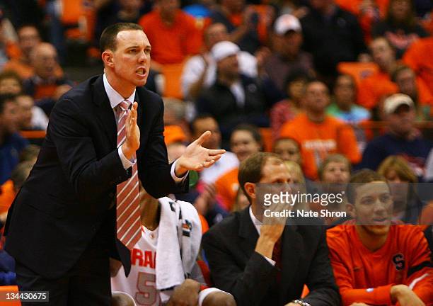Assistant coach of the Syracuse Orange, Gerry McNamara claps from the sideline as assistant coach Mike Hopkins looks on from the bench during the...
