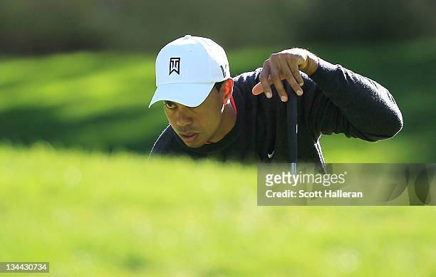 Tiger Woods lines up a putt on the fifth green during the first round of the Chevron World Challenge at Sherwood Country Club on December 1, 2011 in...