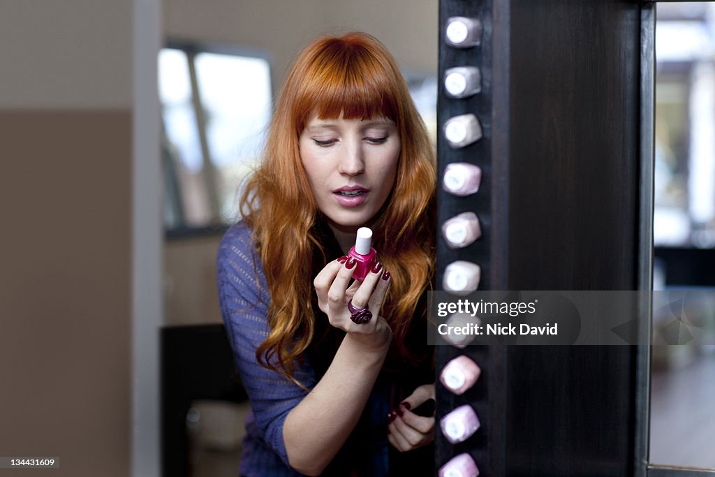 A women choosing a bottle of nail polish in a nail salon