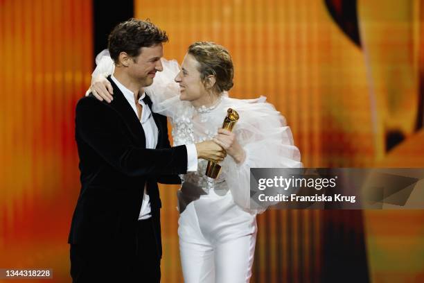 Florian David Fitz presents Maren Eggert with the ‘Beste weibliche Hauptrolle’ award for ‘Ich bin dein Mensch’ on stage during the Lola - German Film...