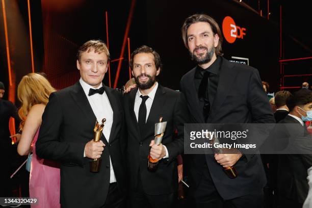 Oliver Masucci, Quirin Berg and Max Wiedemann pose on stage during the Lola - German Film Award at Palais am Funkturm on October 01, 2021 in Berlin,...