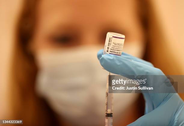 Safeway pharmacist Ashley McGee fills a syringe with the Pfizer COVID-19 booster vaccination at a vaccination booster shot clinic on October 01, 2021...