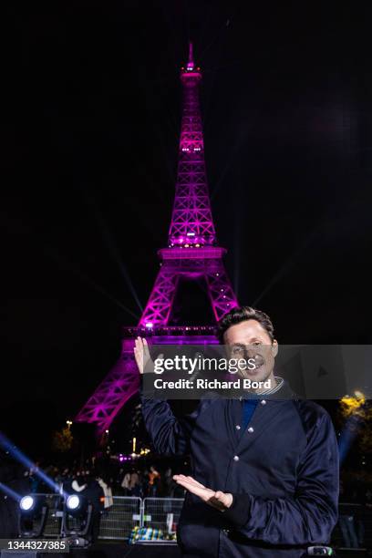 Dj Martin Solveig poses in front of the Eiffel Tower during the «Octobre Rose» by Ruban Rose show as part of Breast Cancer Awareness month during...