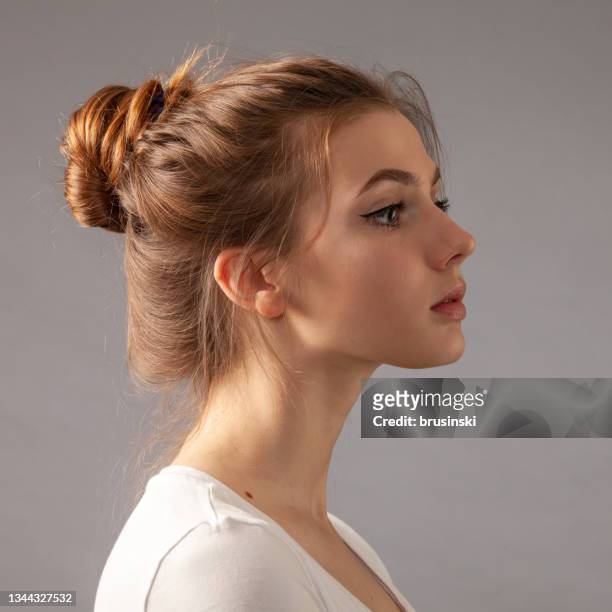 studioporträt einer attraktiven 19-jährigen frau mit braunen haaren - haarknoten stock-fotos und bilder