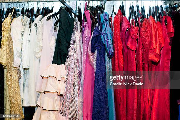 a row of brightly coloured dresses in a vintage clothes shop - gown stock pictures, royalty-free photos & images