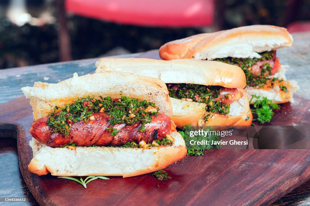 Choripán con chimichurri (chorizo a la parrilla, comida tradicional argentina).