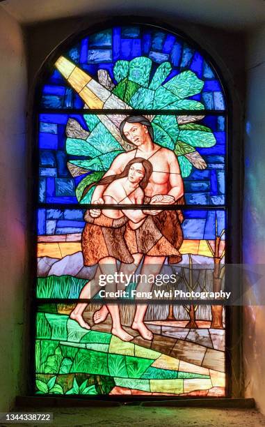 stained glass window depicting adam and eve expelled from garden of eden, st. blaise church, vodnjan, istria, croatia - stained glass angel stock pictures, royalty-free photos & images