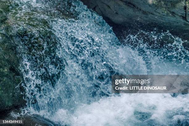 flowing mountain stream water. high speed - slow motion water stock pictures, royalty-free photos & images