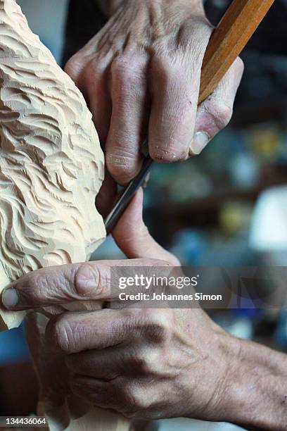 Woodcarver Herbert Haseidl carves a figurine in the shape of a dromedary for a Christmas crèche at his workshop on December 1, 2011 in Oberammergau,...