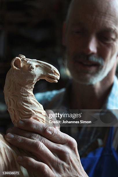 Woodcarver Herbert Haseidl carves a figurine in the shape of a dromedary for a Christmas crèche at his workshop on December 1, 2011 in Oberammergau,...