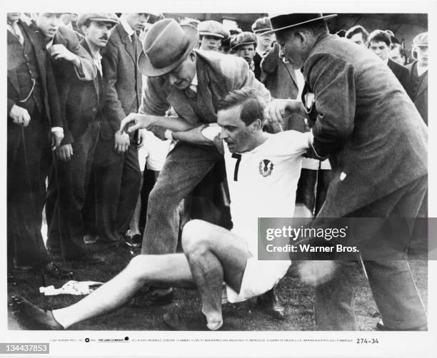 British athlete Eric Liddell, is helped to his feet after a race by running coach Sam Mussabini in a scene from 'Chariots Of Fire', directed by Hugh...