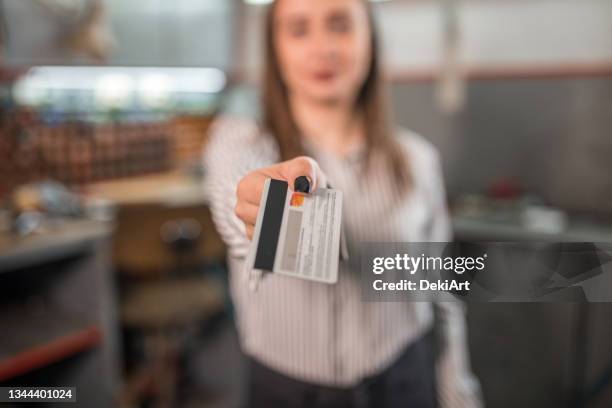 female customer giving credit card at auto repair shop - credit card art stock pictures, royalty-free photos & images