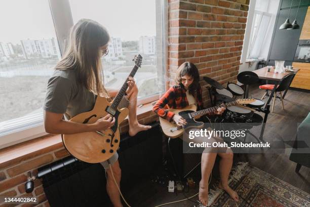 man and woman playing electric guitars together - rehearsal studio stock pictures, royalty-free photos & images