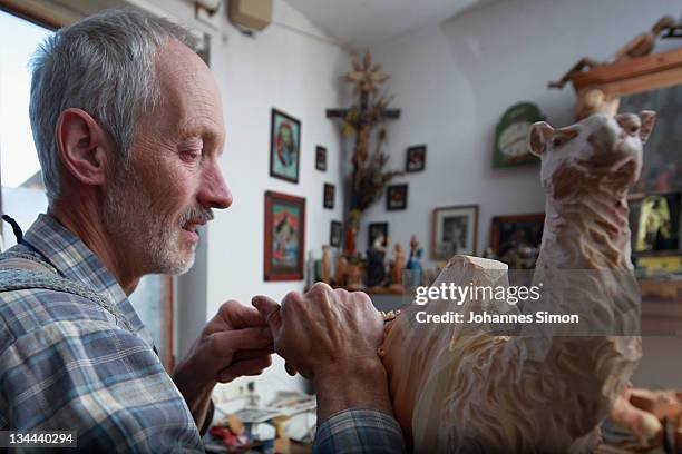 Woodcarver Herbert Haseidl carves a figurine in the shape of a dromedary for a Christmas crèche at his workshop on December 1, 2011 in Oberammergau,...