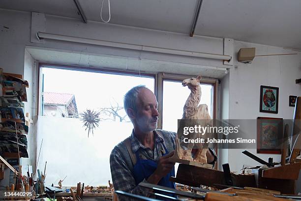 Woodcarver Herbert Haseidl carves a figurine in the shape of a dromedary for a Christmas crèche at his workshop on December 1, 2011 in Oberammergau,...