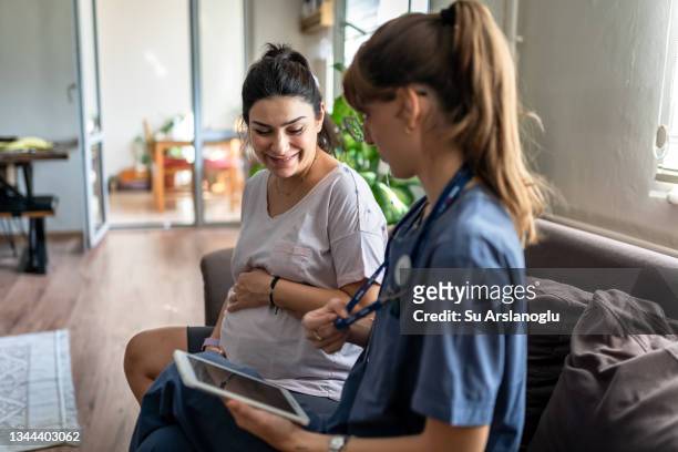 enfermera de atención médica domiciliaria visita a una mujer embarazada en casa - giving birth fotografías e imágenes de stock