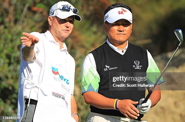 Choi of South Korea chats with his caddie Steve Underwood on the 15th hole during the first round of the Chevron World Challenge at Sherwood Country...