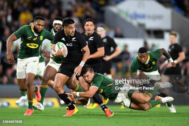 Rieko Ioane of the All Blacks offloads the ball in a tackle during The Rugby Championship match between the South Africa Springboks and New Zealand...