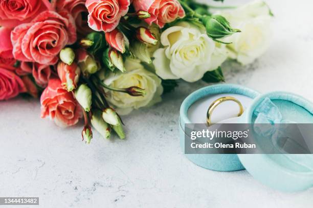 golden wedding ring and roses on white surface. - ring around the rosy stock pictures, royalty-free photos & images