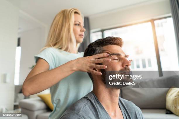 primer plano de un joven que recibe un masaje relajante en el templo de su esposa. - head massage fotografías e imágenes de stock