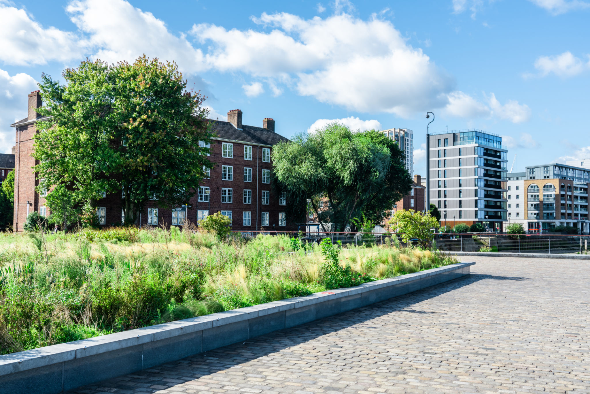 View of a Thames riverside path under blue sky with clouds View of a Thames riverside path under blue sky with clouds
