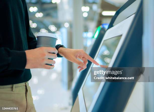 jovem asiático viajando de avião e fazendo auto-check-in no aeroporto usando uma máquina - monitor tátil - fotografias e filmes do acervo