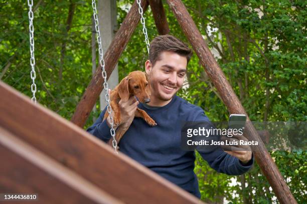 young man taking selfie with his dog at autumn park.pet and people concept - park man made space stock pictures, royalty-free photos & images