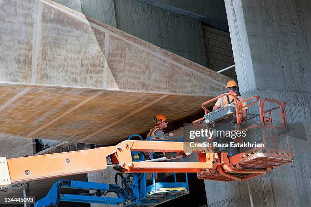 construction workers on jcb help steer bridge to l - uk photos stockfoto's en -beelden