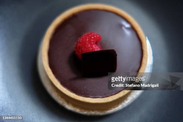 round dessert dessert with raspberry in the center on a dark background - chocolate pudding foto e immagini stock
