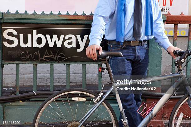 business man with bike against subway sign - underground sign 個照片及圖片檔