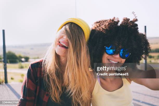 portrait of two teenage girls - hiding from selfie stockfoto's en -beelden