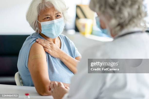 paciente mayor que recibe con éxito su vacuna - vaccine fotografías e imágenes de stock