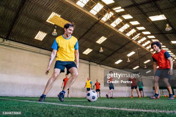 payers in action during soccer match in indoor field - indoor soccer stock pictures, royalty-free photos & images