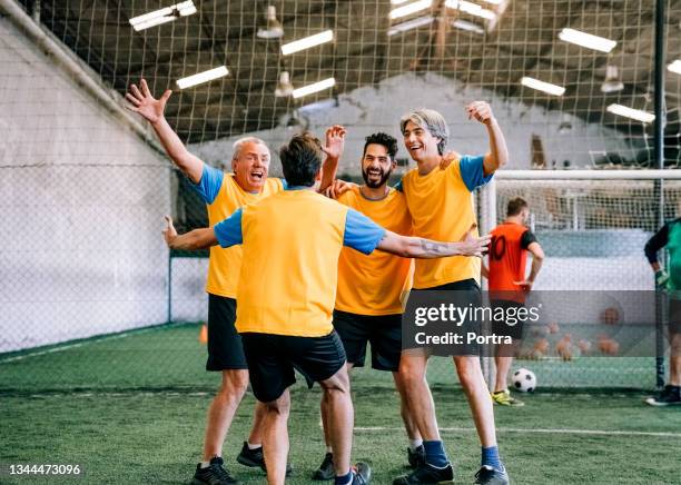 erfolgreiche fußballspieler feiern nach dem sieg - hallenfußball wettbewerb stock-fotos und bilder