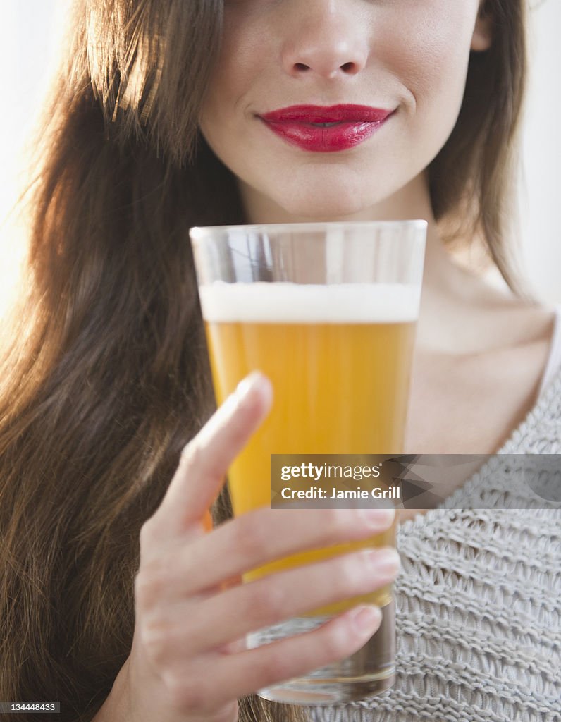 Young woman holding pint of beer