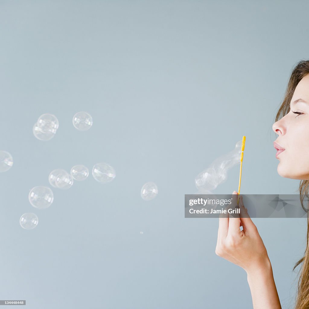 Young woman blowing bubbles