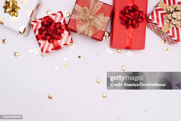 winter pattern with small christmas gifts wrapped in red paper on white background. - gift background stock pictures, royalty-free photos & images