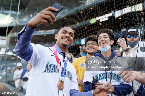 Julio Rodríguez, a prospect with the Seattle Mariners and bronze medalist with Dominican Republic, takes photos with fans before the game against the...