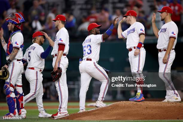 Adolis Garcia of the Texas Rangers celebrates with Brock Holt of the Texas Rangers beat the Cleveland Indians 7-2 at Globe Life Field on October 02,...