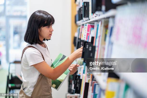 図書館で本を探している若い思春期の少女 - bookstore ストックフォトと画像