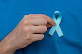 man hand holding blue ribbon. Blue november. Prostate Cancer Prevention Month. Men's health.