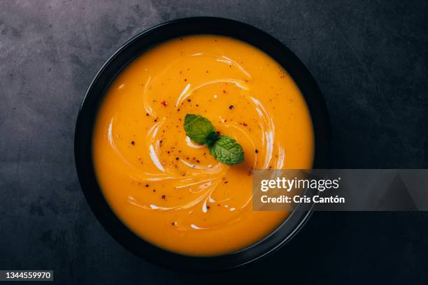 pumpkin soup with cream on black background - pumpkin soup stock pictures, royalty-free photos & images