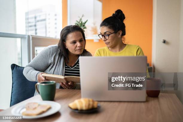 lesbian couple doing home finances together - union gay stockfoto's en -beelden