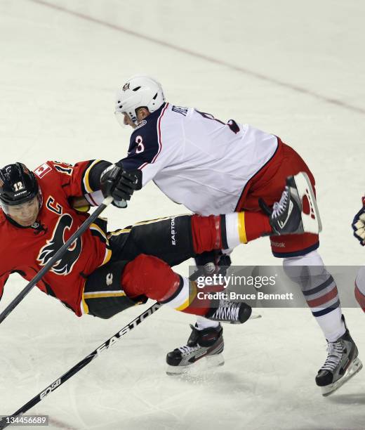 Marc Methot of the Columbus Blue Jackets dumps Jarome Iginla of the Calgary Flames at the Scotiabank Saddledome on December 1, 2011 in Calgary,...