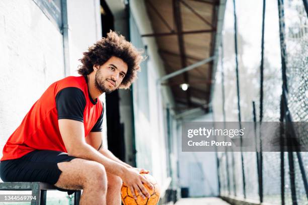 young player sitting outside soccer court - indoor soccer stock pictures, royalty-free photos & images