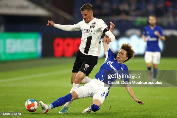 Kou Itakura of FC Schalke 04 tackles Stefan Kutschke of FC Ingolstadt 04 during the Second Bundesliga match between FC Schalke 04 and FC Ingolstadt...