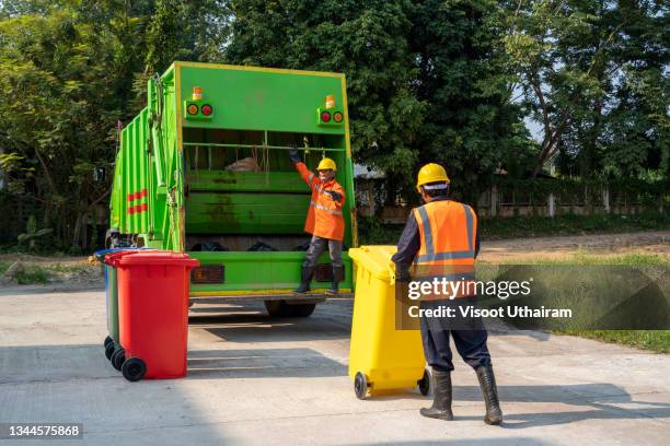 garbage collector loads garbage truck with household waste. - camion de basura fotografías e imágenes de stock