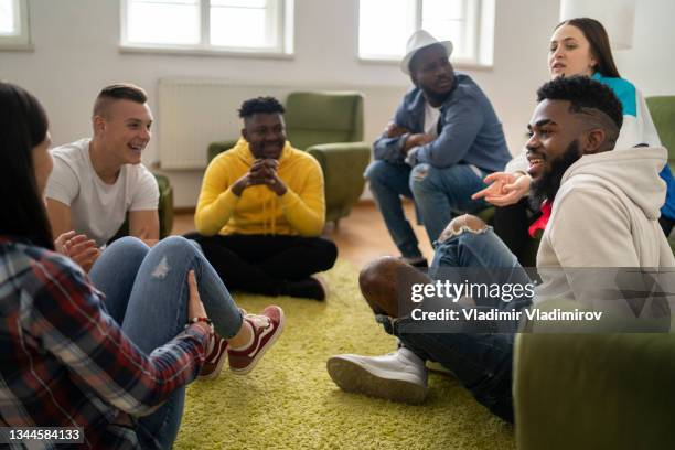 a small group sitting in a circle are having a friendly discussion - addiction recovery stock pictures, royalty-free photos & images