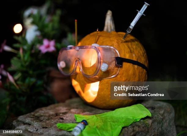 halloween party in pandemic with vaccines covid019 protective mask gloves. - scary pumpkin faces stock pictures, royalty-free photos & images